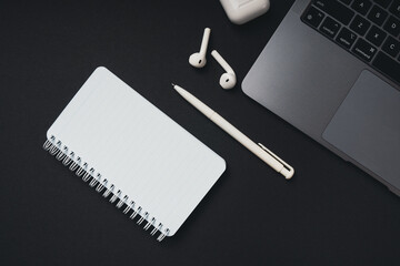 Empty white notepad with copy space, pen, laptop are on the table, top view.