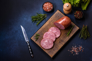 Delicious fresh smoked sausage cut with slices on a wooden cutting board