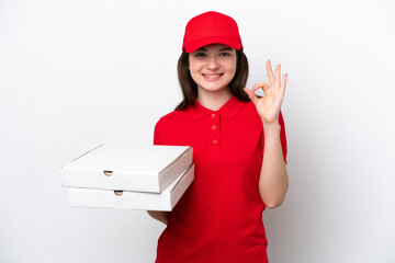 Young Russian pizza delivery picking up pizza boxes isolated on white background showing ok sign...