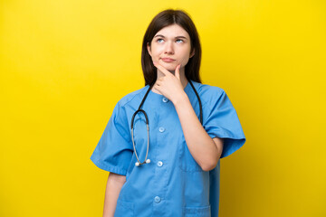 Young surgeon doctor Russian woman isolated on yellow background having doubts