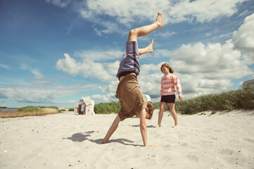Happy teen children joyful playing on white beach at summer holidays