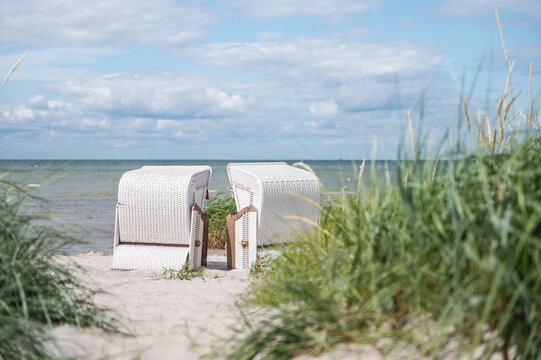 Romantic sea scene at white beach with beach chair at summer sunny day in north Germany