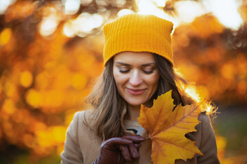 happy elegant woman in beige coat and orange hat