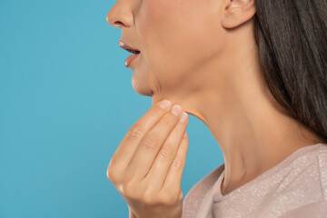 A close-up and side profile view of a caucasian lady pinching the loose skin at the front of her...