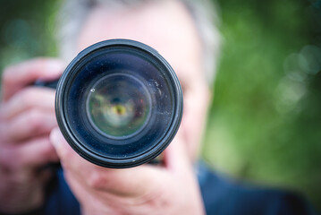 Close-up camera lens with dirty glass in the photographer's hands