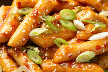 Tteokbokki, Topokki fried rice cake stick in black bowl. Korean street food