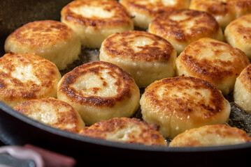 Cheesecakes or Syrniki on a pan. Russian and Ukrainian Cuisine.