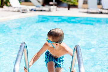 8-year-old boy leaves the pool happy. On a happy vacation in Corfu, Greece