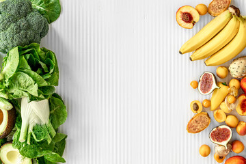 A variety of fresh vegetables and fruits on a white background, flat lay.