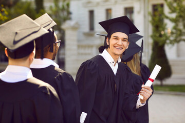 Happy young man having fun at his graduation. Outdoor portrait of a cheerful, joyful university or...