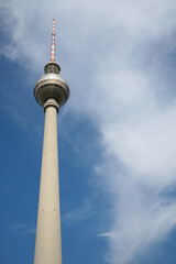 The Berlin Television Tower (Fernsehturm Berlin and Berliner Fernsehturm in German), the tallest structure in Germany, with a cloudy blue sky as a backdrop on a sunny day.  Image has copy space.