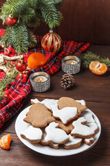 Delicious homemade Christmas cookies in the form of a rabbit and a Christmas tree on a wooden table decorated with New Year's decor. Copy spase