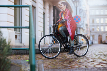 Obraz premium smiling woman outside on city street riding bicycle