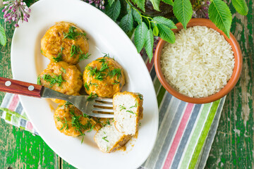 Meatballs with chicken and rice in sour cream sauce. Wooden background