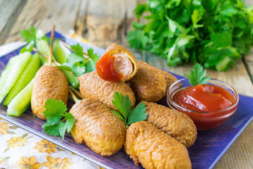 Corn dogs fried in cornmeal batter served on a ceramic plate. Wooden background. Selective focus