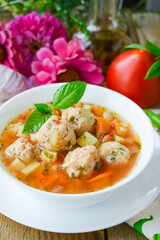 Tomato soup with chicken meatballs. Vegetable soup with chicken. Wooden background