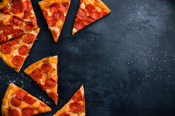Tasty pepperoni pizza on black concrete background. Top view of hot pepperoni pizza. With copy...