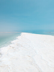 Landscape view on Dead Sea salt crystals formations, clear cyan green water at Ein Bokek beach, Israel