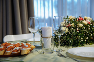 The table is decorated with plates and glasses with flowers on the table