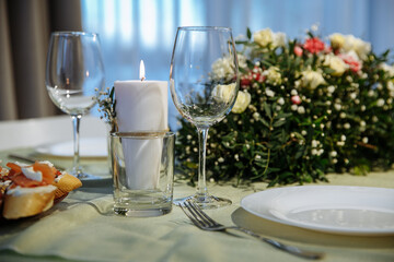 The table is decorated with plates and glasses with flowers on the table