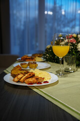 Glasses with yellow juice on the table, with flowers in the room