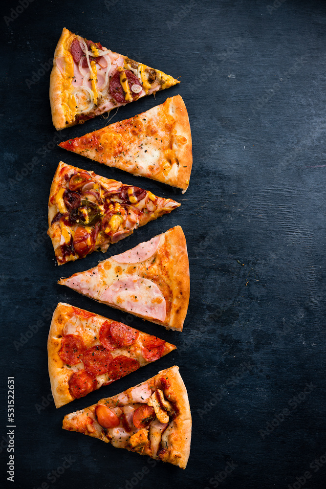 Wall mural Slices of Pizza with salami, ham cheese and bacon Top view, copy space