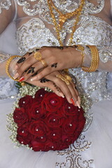 hands of the bride and red roses flowers bouquet 