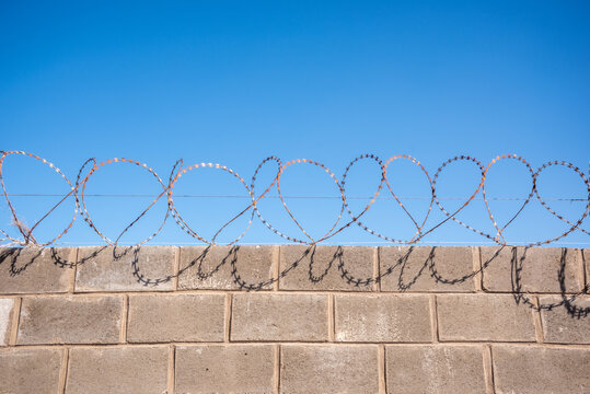 barbed wire fence against blue sky