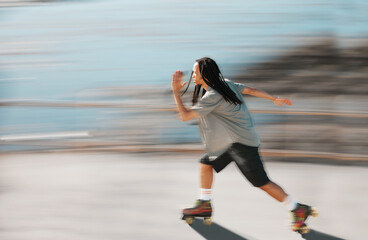Fitness, exercise and a man on roller skates moving fast with blurred background. Action, movement and an adrenaline rush skating in road. Speed, sports and a dreadlocks skater having fun in the sun. © David Lahoud/peopleimages.com