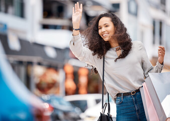 Urban woman, calling taxi and retail bags after positive shopping trip in a busy city. Young girl in the street with store purchase packages while looking for transport service in town.