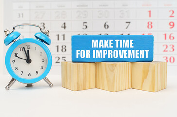 Against the background of the calendar, an alarm clock and a blue block with the inscription - Make...