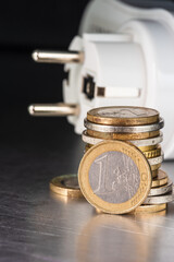 Euro coins and electrical plug, concept of inflation and increasing energy prices