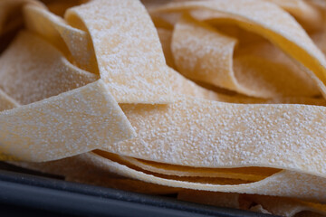 pile of uncooked raw Italian pasta, yellow background, food background, place for your text 