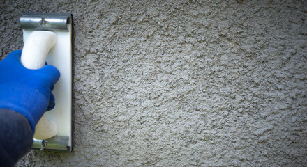 Leveling a gray concrete wall. Hand with a rectangular trowel.Repair and construction. Interior decoration.