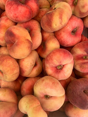 Peach background. Peaches on a food farmers market in London. Fresh organic flat peaches. Fruit. Juicy ripe and ready to eat