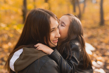 Fototapeta premium Mother and daughter spend time together in autumn yellow park. Season and single parent concept.