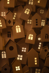 light from the windows of small decorative, white houses on the street of a European city during the winter seasonal holidays