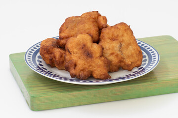 Plato con buñuelos de bacalao sobre fondo blanco