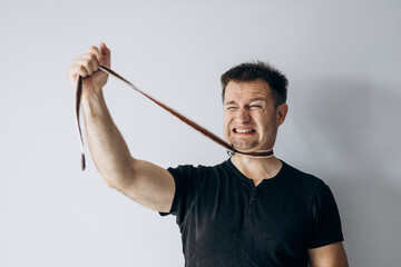 World Mental Health Day. A man in a black t-shirt strangles himself with a rope.