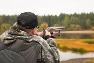 Duck hunting in autumn. A man with a gun is hunting ducks.