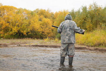 Naklejka premium Duck hunting in autumn. A man with a gun is hunting ducks.