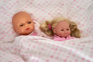 two little dolls in a bed