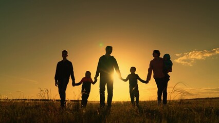 Happy big family with children are walking in park, sun. People travel in nature. Mom, dad, son are walking together on grass, holding hands, teamwork. Family walk on field. Healthy big family concept