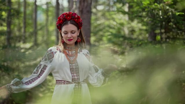 Beautiful ukrainian woman dancing alone in fir forest, Carpathian mountains nature. Girl in traditional embroidery vyshyvanka dress. Ukraine, freedom, ethnic national costume
