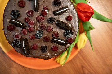 chocolate cake with three chocolates, fresh berries on the cake. cake poured with chocolate, the most chocolate cake