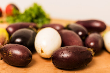 Blue and white eggplants are on the table in the kitchen
