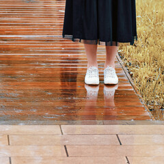 Legs of woman standing in the rain in bad autumn weather