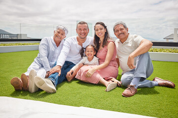 Portrait of happy big family with girl, love and a smile while sitting on backyard, lawn or grass. Grandfather, grandmother and mom with dad and child or kid bonding outside home in the sunshine.