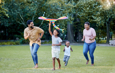 Black family, kite and outdoor fun with parents and children having fun and playing outside at a...