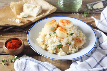 Italian cuisine. Plate of scallop risotto, olive oil and parmesan cheese
